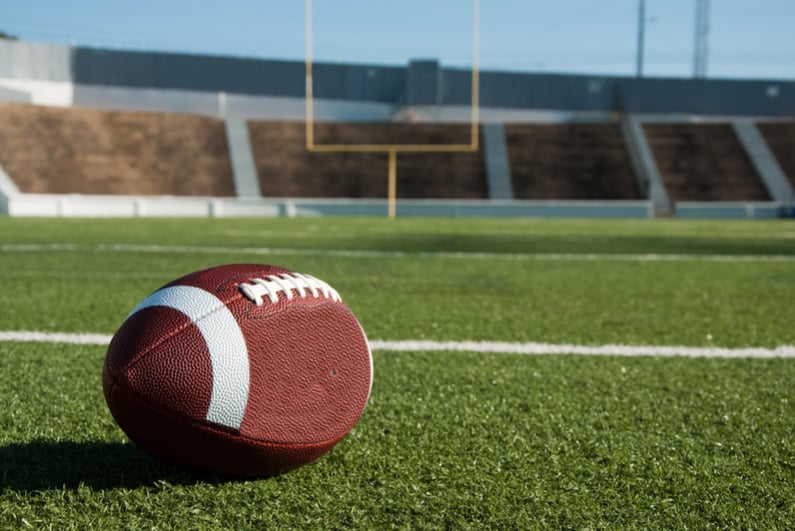 American football on field with goalpost in background