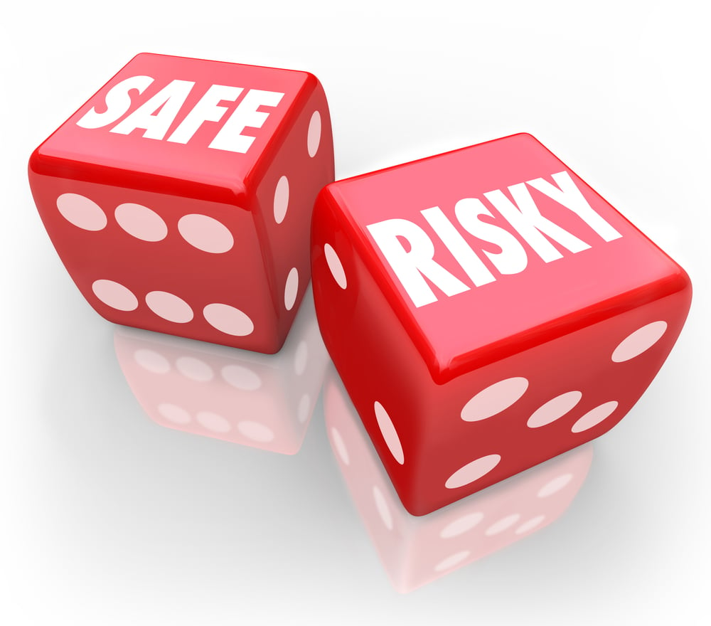 red gambling dice with the words safe and risky printed on one face