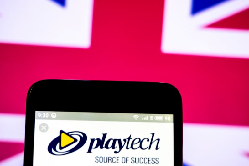 Playtech logo on a smartphone with UK flag in background