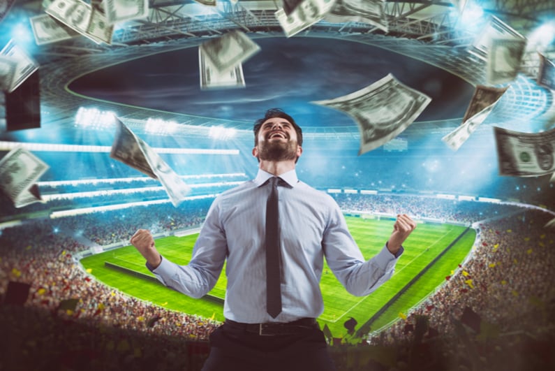 man rejoices in a stadium as cash falls from the sky