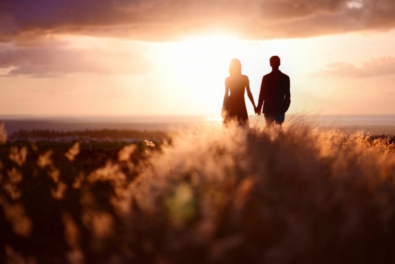 Young couple holding hands at sunset