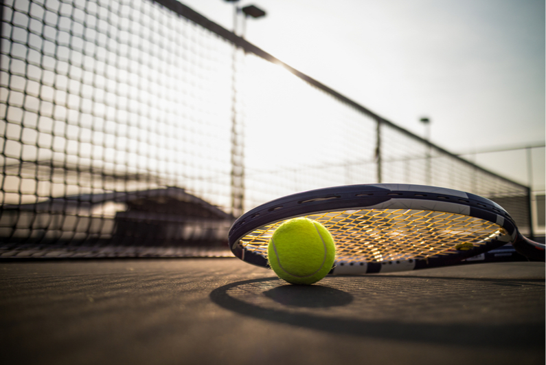 Tennis ball and racquet on a court