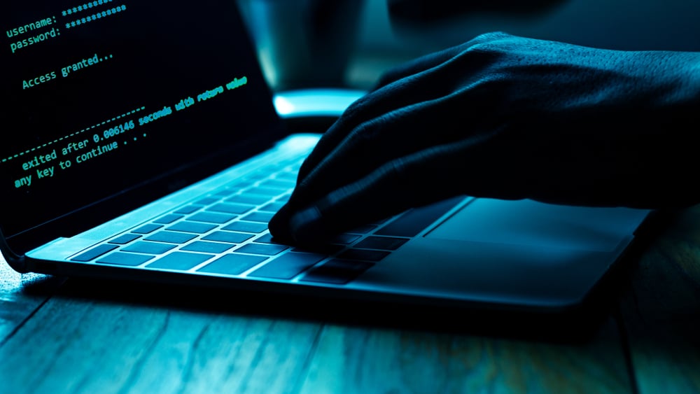 A person hacking into a user account on a laptop